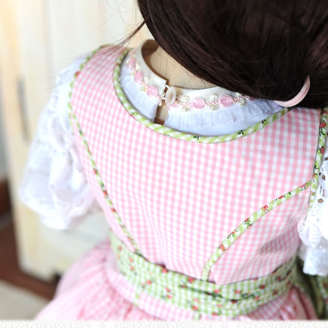 Schnittmuster Kinderdirndl Resli 01 | TOSCAminni Detailansicht des Mieders vom Kinderdirndl Resli mit grün-weißem Karomuster und Paspelierung. Das Schnittmuster Kinderdirndl Gr. 80-140 zeigt hier die saubere Verarbeitung der Wiener Nähte und des Ausschnitts.